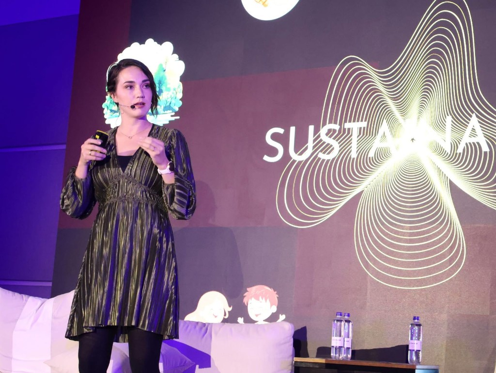 Enrike Maree speaking on stage at a live event